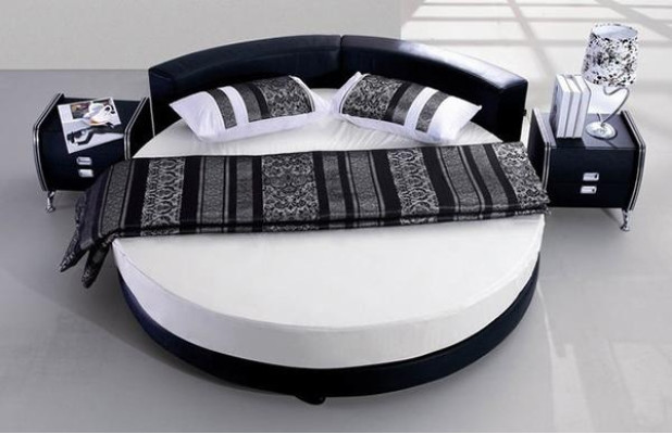 Schwarzes rundes Bett mit modernem Design, eleganten Details und Sofa