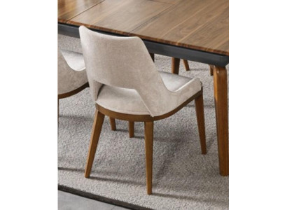 Ein lakonischer, moderner Stuhl mit hohen Beinen aus Holz und Polsterung in einer angenehmen, hellen cremefarbenen Farbe für das Esszimmer