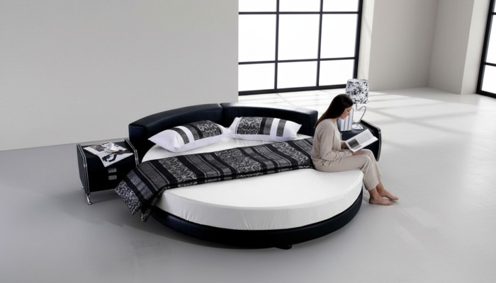 Schwarzes rundes Bett mit modernem Design, eleganten Details und Sofa
