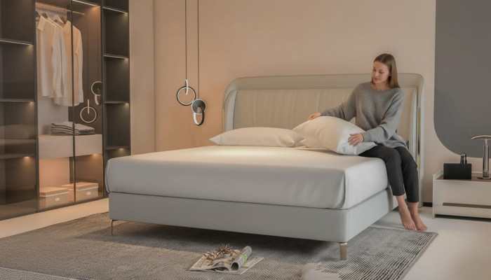 Modernes luxuriöses Bett in grauer Farbe mit elegantem goldenen Kopfteil